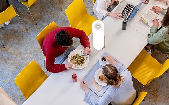Studierende arbeiten und essen im Food Court