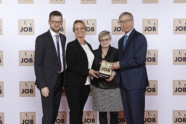 Jörg J. Schmitz, Nadja Schutz und Dr. Gaby Jungnickel nehmen das TOP JOB-Siegel von Wolfgang Clement entgegen.