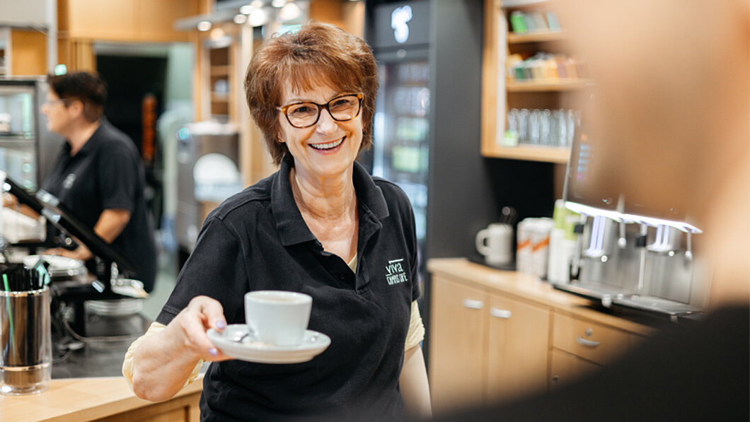 Servicekraft serviert Kaffee