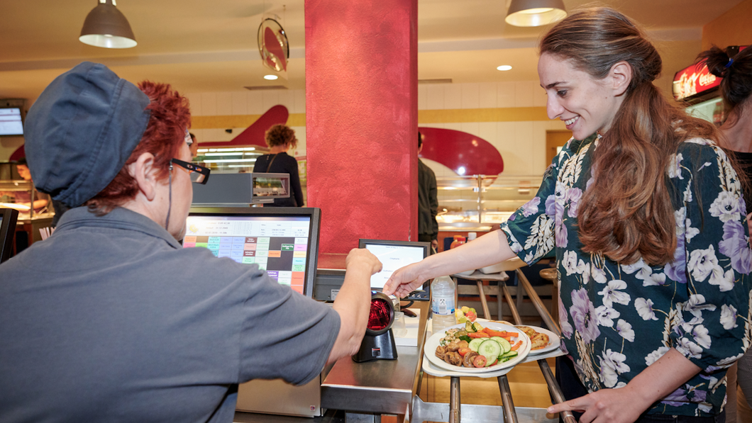 Studentin bezahlt ihr Essen an der Kasse im venusberg bistro.