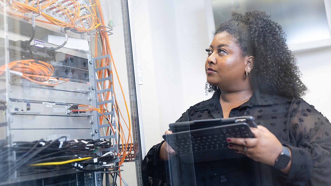 Eine IT Sachbearbeiterin überprüft Kabel