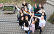Bild von oben fotografiert auf das Team der Campus-Kita Mainz, die die Hände im Kreis zusammenhalten - Teamwork
