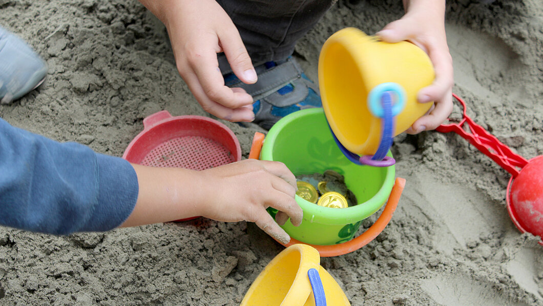 Kinderhände spielen im Sandkasten