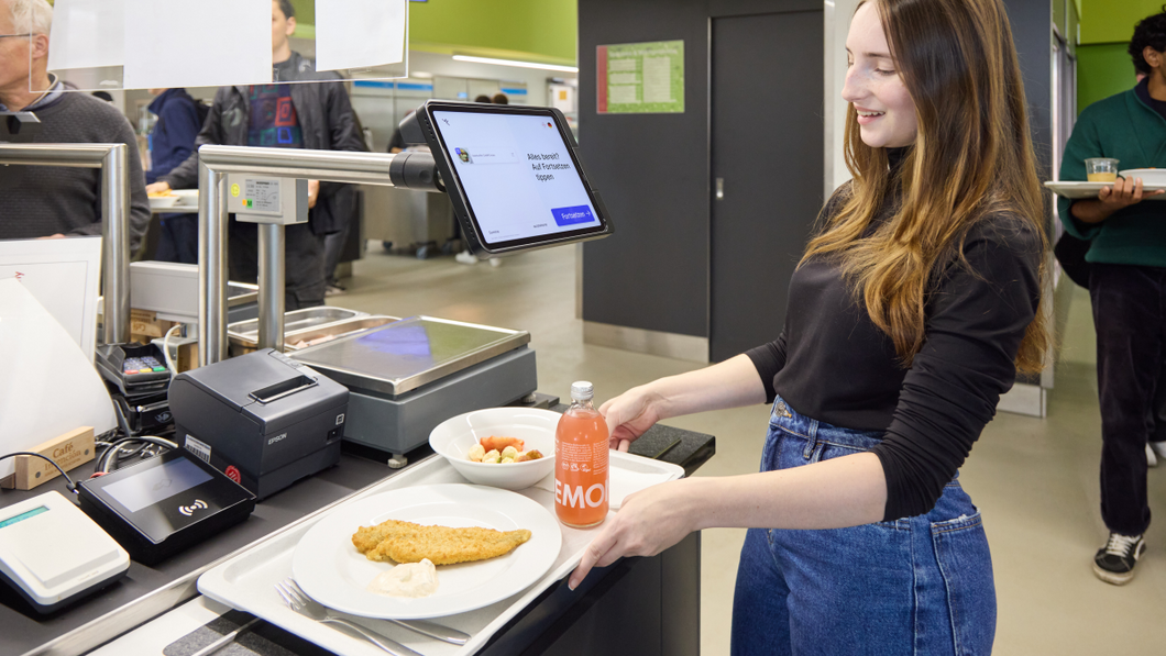 Studentin bezahlt ihr Essen an der KI-gesteuerten Selbstbedienungskasse.