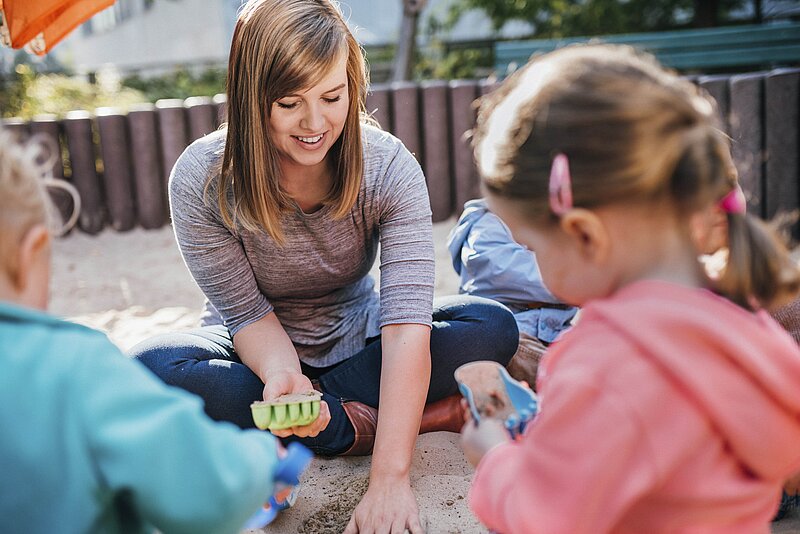 Erzieherin interagiert mit Kindern