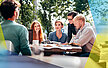 Mehrere Studierende sitzen im Außenbereich einer Cafeteria